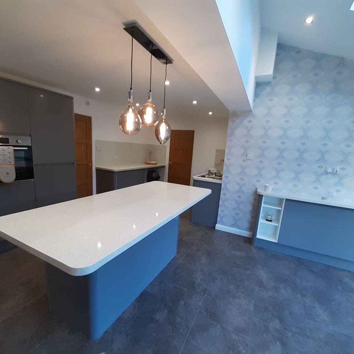 Grey gloss kitchen with a white sparkle island worktop